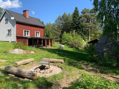 Cozy Zweeds huis met openhaard en grote tuin في Ramsele: حديقة امام بيت احمر مع قطعة خشب
