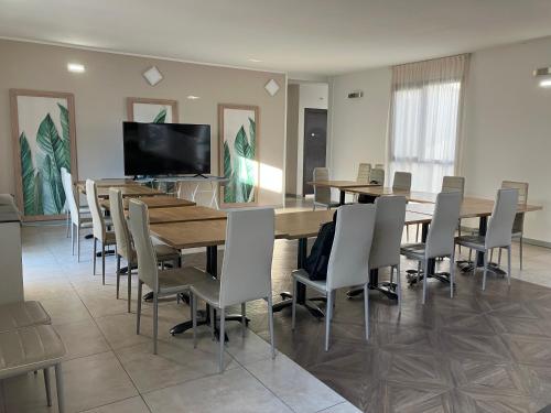 a conference room with a table and chairs and a flat screen tv at Aquasole in Mercallo