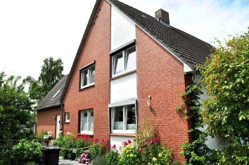 ein rotes Backsteinhaus mit schwarzem Dach in der Unterkunft Gästehaus Steinhardt Appartement Nr 04 in Timmendorfer Strand