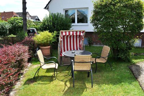 einen Tisch und Stühle im Hof mit einem Tisch und einer Decke in der Unterkunft Gästehaus Steinhardt Appartement Nr 04 in Timmendorfer Strand