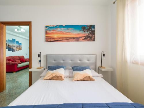 1 dormitorio con 1 cama blanca grande y 2 almohadas en Bluebeach, en Las Palmas de Gran Canaria