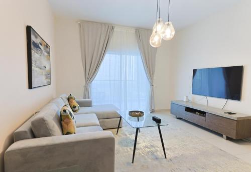 uma sala de estar com um sofá e uma televisão de ecrã plano em EliteRetreat - SeaView - Gym & Pool Access - Reem Island em Abu Dhabi