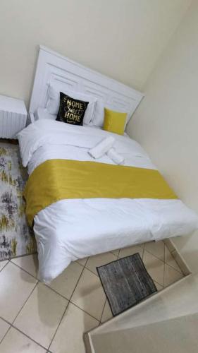 ein Schlafzimmer mit einem großen Bett und einer gelben Decke in der Unterkunft Amir in Nairobi