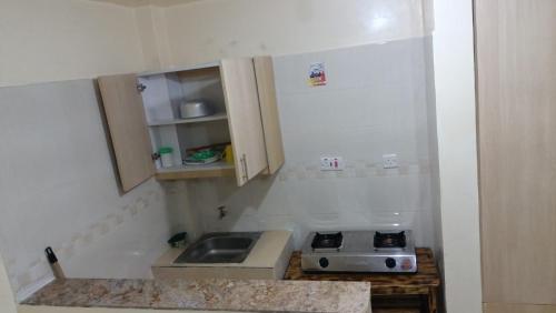 eine kleine Küche mit einer Spüle und einem Herd in der Unterkunft Amir in Nairobi