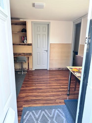 Habitación con escritorio, mesa y puerta en Self-contained Annex for short stay, en Bushey