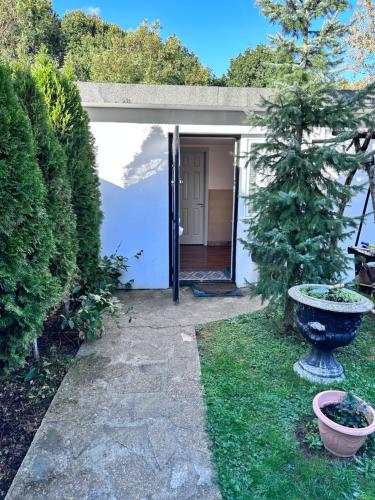 una entrada al jardín de una casa con porche en Self-contained Annex for short stay, en Bushey