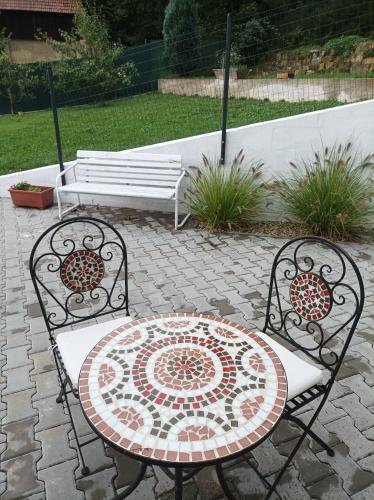 two chairs and a table with a mosaic table and bench at U kapličky, Boskovice in Boskovice