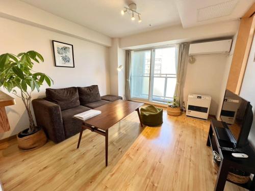 a living room with a couch and a table at AMSタワー中島 in Sapporo