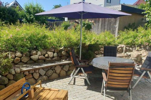 einen Tisch und Stühle mit Sonnenschirm auf einer Terrasse in der Unterkunft Haus am Strand Ferienwohnung Nr 01 in Niendorf