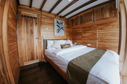 1 dormitorio con 1 cama grande en una habitación de madera en Labuan Bajo Trip, en Nggorang