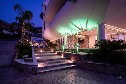 a building with stairs in front of it at night at New River Hotel in Borgetto