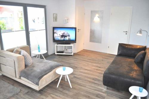 uma sala de estar com um sofá e uma televisão de ecrã plano em Haus Chalet 21 Ferienhaus em Haffkrug