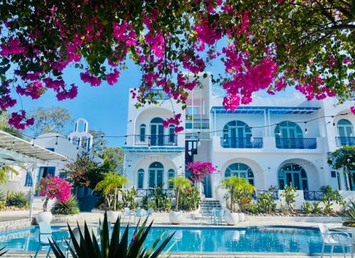 a villa with a swimming pool and pink flowers at Santorini Villa Cam Ranh in Cam Ranh