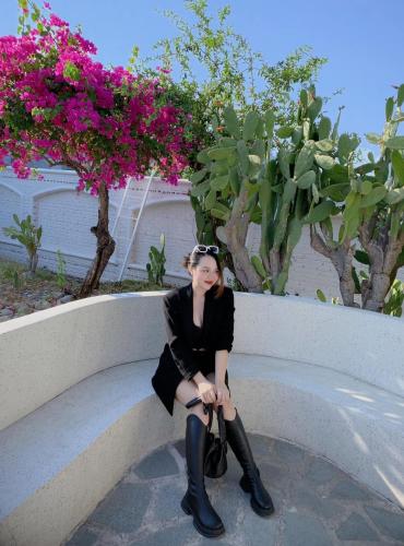 a woman in a black dress sitting on a bench at Santorini Villa Cam Ranh in Cam Ranh