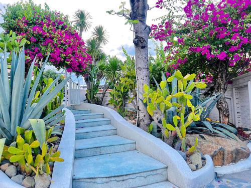 a set of stairs in a garden with pink flowers at Santorini Villa Cam Ranh in Cam Ranh
