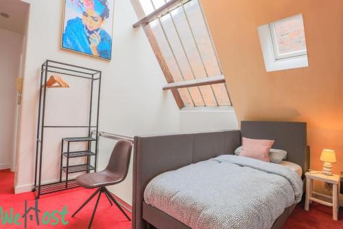 a small bedroom with a bed and a chair at La porte verte, superbe triplex 16P in Arras