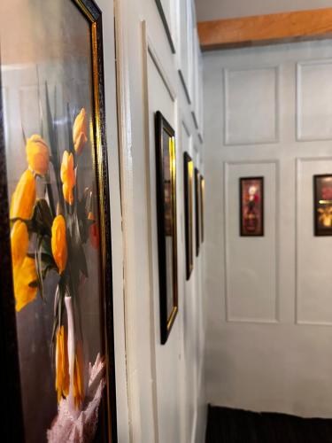 a framed picture of yellow flowers on a wall at The Forest Way Loft by YEMBERZAL in Srinagar