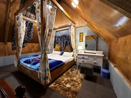 - une chambre avec un lit à baldaquin et un bureau dans l'établissement The Forest Way Loft by YEMBERZAL, à Srinagar