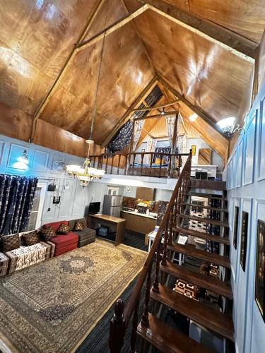 a large living room with a wooden ceiling and stairs at The Forest Way Loft by YEMBERZAL in Srinagar