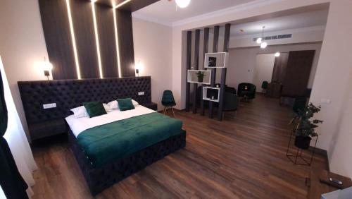 1 dormitorio con 1 cama grande con sábanas verdes en Bizi House Accommodation, en Drobeta-Turnu Severin