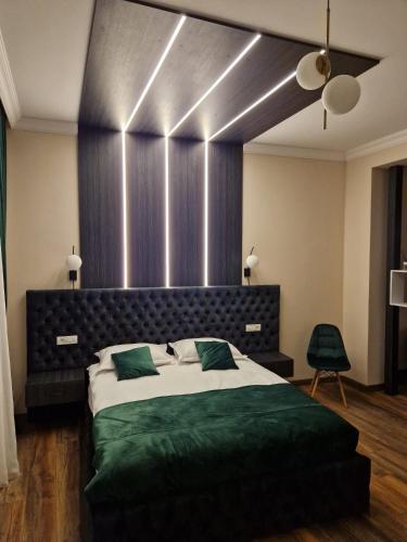 a bedroom with a large bed with green sheets at Bizi House Accommodation in Drobeta-Turnu Severin