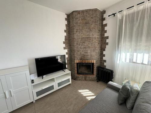 ein Wohnzimmer mit einem TV und einem Kamin in der Unterkunft apartamento arroyo in Benaocaz