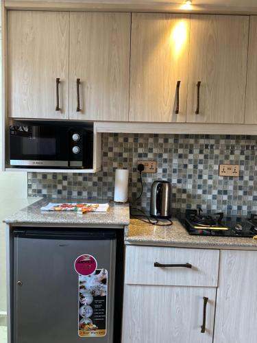 a kitchen with a black refrigerator and a microwave at Regency Homes II in Eldoret