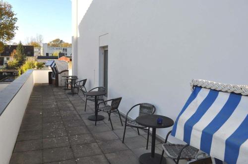 a row of chairs and tables on a patio at Landhaus Köppen Ferienwohnung Nr 15 in Timmendorfer Strand