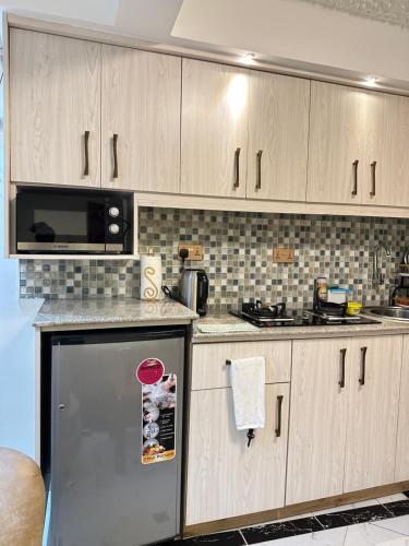 a kitchen with wooden cabinets and a stainless steel refrigerator at Regency Homes II in Eldoret