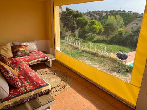 a living room with a couch and a large window at 2Bedroom house with Swimming Pool and View in Moçarria