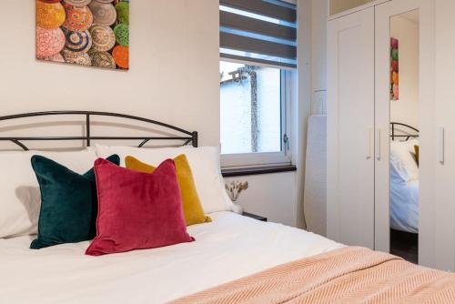 - une chambre avec un lit et des oreillers colorés dans l'établissement Brand New Must See Stylish Apt W/Free Parking, à Leicester