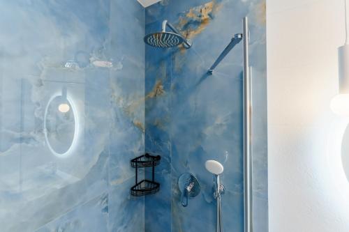 a bathroom with a shower with a blue wall at Bel Mare 107 F in Międzyzdroje