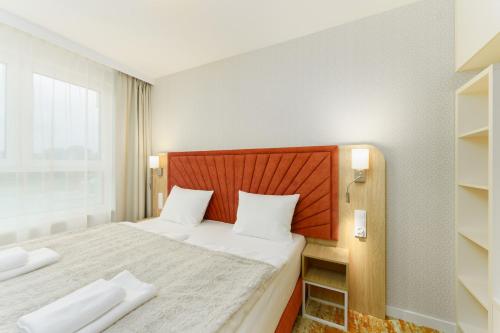 a bedroom with a large bed with a wooden headboard at Bel Mare 107 F in Międzyzdroje