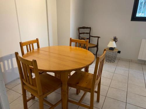 - une table et des chaises en bois dans l'établissement Appartement Cosy Villieu, à Villieu