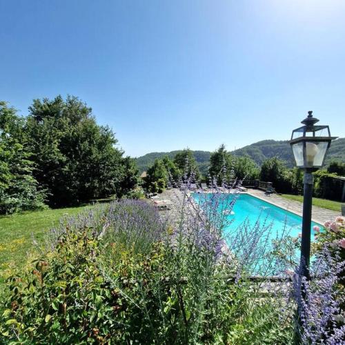 a swimming pool in a field with a street light at Borgo il cantuccio - Casa Simona con piscina condivisa in Molino di Renzetti