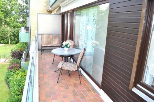 een patio met een tafel en stoelen op een balkon bij Lisas Nest Ferienwohnung in Timmendorfer Strand