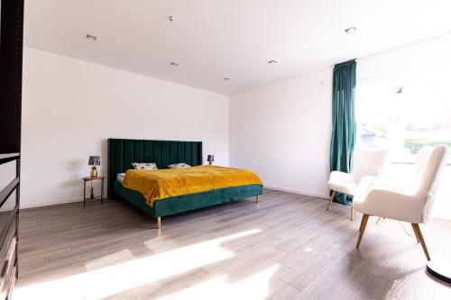 a bedroom with a bed and two chairs in it at Design Apartment zentral für 6 in Andernach: Ausblick, WiFi, Küche in Andernach