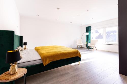 a bedroom with a bed with a yellow blanket on it at Design Apartment zentral für 6 in Andernach: Ausblick, WiFi, Küche in Andernach