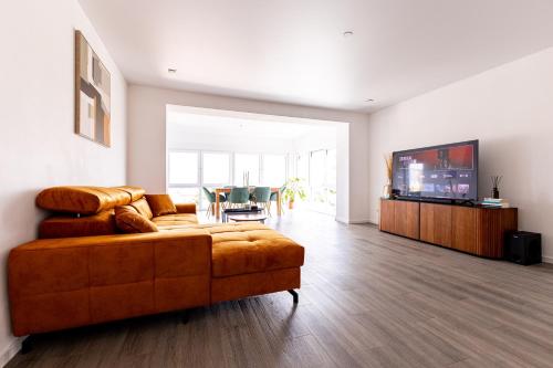 a living room with a couch and a flat screen tv at Design Apartment zentral für 6 in Andernach: Ausblick, WiFi, Küche in Andernach