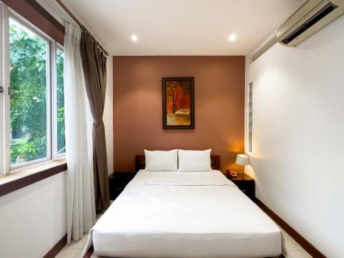 a bedroom with a bed and a window at Hoang Yen Hotel - Phu My Hung in Ho Chi Minh City