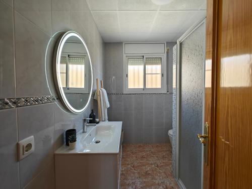 a white bathroom with a sink and a mirror at La caseta del canal in Deltebre