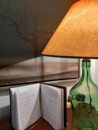 a lamp and a book on a table next to a vase at Aphrodite's Coast Retreat House! in Galaxidhion