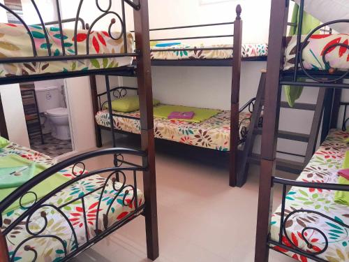 a room with three bunk beds in a room at Liturs Travel Services / Homestay / Rent a Car in Bacolod
