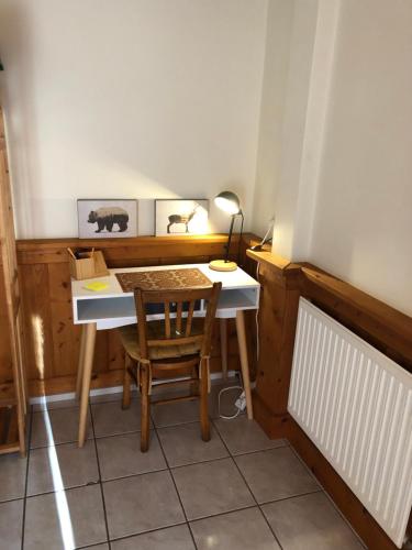 a desk with a chair and a table with a lamp at Gîte du vieux moulin in Ravilloles