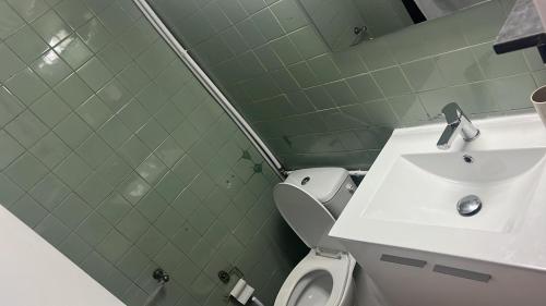een badkamer met een witte wastafel en een toilet bij Estoril big beach in Estoril
