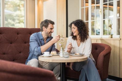a man and a woman sitting at a table at Biohotel Leutascherhof in Leutasch