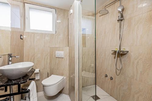 a bathroom with a shower and a toilet and a sink at ForS Resort & Spa in Belgrade