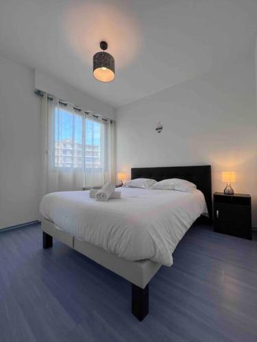 une chambre blanche avec un grand lit et une fenêtre dans l'établissement Le Red Light : Apt 4 Prs, Clim, 300m des plages, à Antibes
