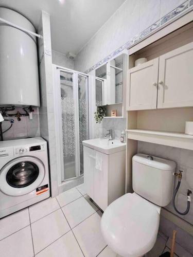 La salle de bains blanche est pourvue de toilettes et d'un lave-linge. dans l'établissement Le Red Light : Apt 4 Prs, Clim, 300m des plages, à Antibes