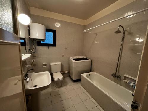 a bathroom with a toilet and a tub and a sink at 4 bedrooms villa with private pool in Tunis village faiuym in Qaryat at Ta‘mīr as Siyāḩīyah